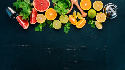 Preparation for preparing a cocktail of citrus fruit and mint. Lemon, grapefruit, lime, orange. On a wooden background. Top view. © Yaruniv-Studio