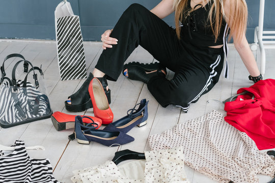 personal style consultant or fashion stylist choosing clothing to create a new image for her client. trendy clothes and accessory items scattered on the floor.