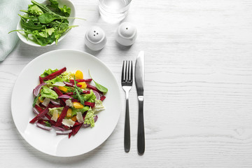 Plate with delicious beet salad on wooden table, top view