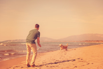 Fototapeta premium man with dog enjoying free time on the beach