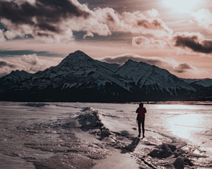 Fototapeta premium A frozen lake hiker in sunset