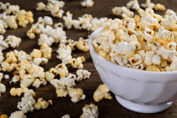 Air salty popcorn.A bowl of popcorn on a wooden table.Salt popcorn on the wooden background .  With space for text.Top view.popcorn texture.Chees .