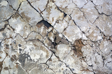Old clay plaster, cracked on the wall. Deep cracks and beautiful texture.