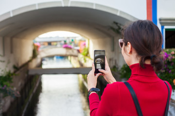 Young traveler woman taking a photo of cozy spanish town