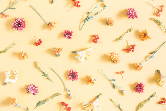 Fototapeta Autumn composition. Pattern made of orange and yellow flowers on pastel yellow background. Autumn, fall concept. Flat lay, top view