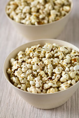 Frischer hausgemachter Popcorn mit Käse, Salz, Knoblauch und Oregano, fotografiert mit natürlichem Licht (Selektiver Fokus, Fokus in die Mitte der ersten Schüssel)