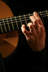Fototapeta premium Man playing acoustic guitar close-up performance
