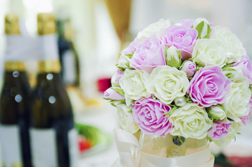 Wedding bouquet and bottles with champagne. Festive feast.