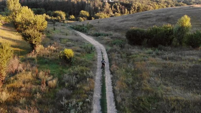 aerial view of cyclist walking down mountain road