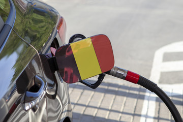 Fueling car with petrol pump at a gas station.