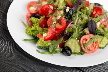 Greek salad with fresh vegetables on background