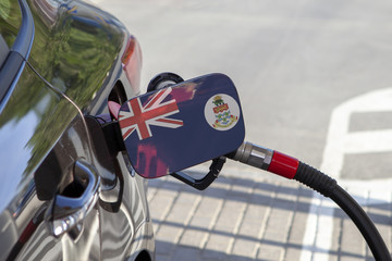 Fueling car with petrol pump at a gas station.
