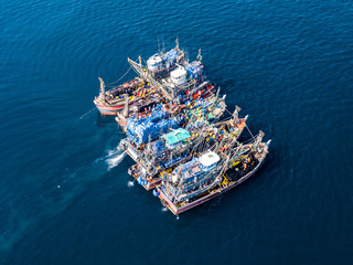 Aerial view of a large number of fishing trawlers operating together illegally in a marine reserve