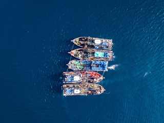 Aerial view of a large number of fishing trawlers operating together illegally in a marine reserve