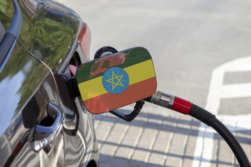 Fueling car with petrol pump at a gas station.