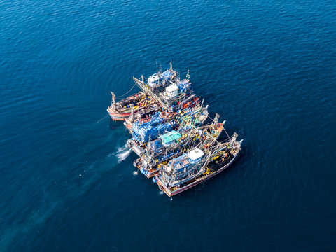 Aerial view of a large number of fishing trawlers operating together illegally in a marine reserve