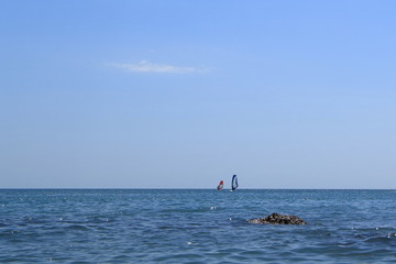 Walk on the sea on a board with a sail.