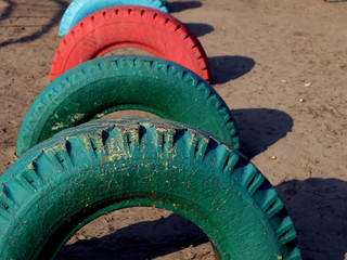 Old car tires on the playground. Old multi-colored car tires.