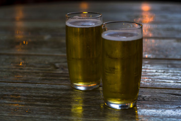Glasses of beer on wooden table