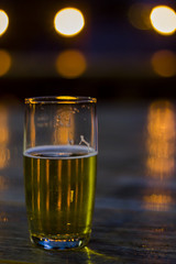 Glass of beer with blurred lights on background