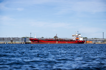 Red cargo ship in the port of Riga on a sunny spring day, Latvia