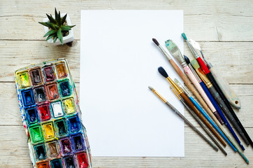 Artist paint brushes on the wooden background