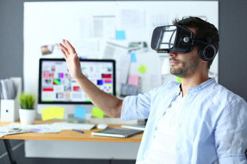 Young male software programmer testing a new app with 3d virtual reality glasses in office.