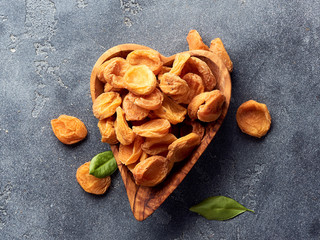 Fototapeta premium Dried apricots on gray concrete background. Top view.