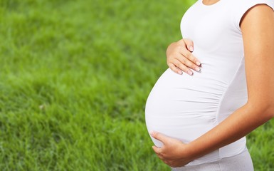 Pregnant young woman keeps the stomach