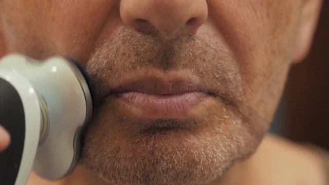 Man Shaving With Electric Shaver