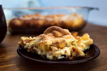 Beautiful delicious dessert-apple casserole with cottage cheese and semolina, laid on a round plate.