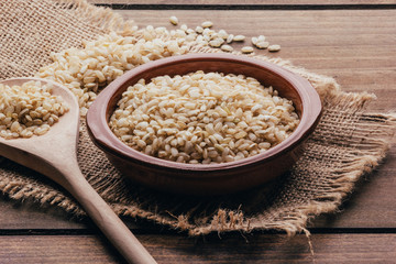 Full container with brown rice, rustic style