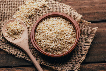 Full container with brown rice, rustic style