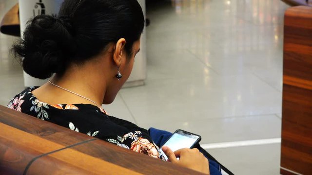 a woman scrolls through the messages in the phone.