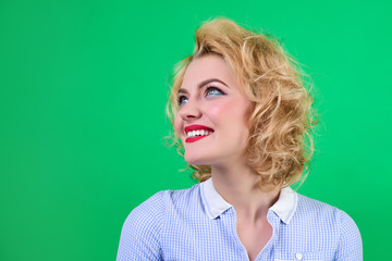 Pin up. Retro style. Woman with bright makeup. Portrait of smiling pin up woman. Pin-up clothes. Portrait of beautiful pin-up girl in blue dress. Isolated on green background.