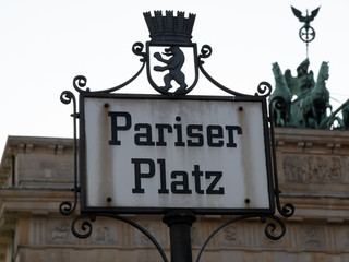 Old Street Sign Pariser Platz With The Quadriga of Brandenburg Gate In Background, Selected Focus