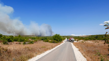 Fototapeta premium Fire brigade and people watching the incoming wildfire