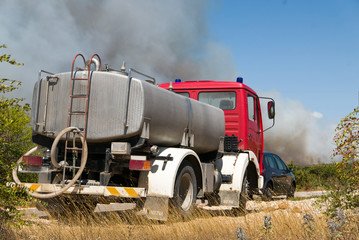 Obraz premium Fire truck waiting to pour water and fight back the wildfire