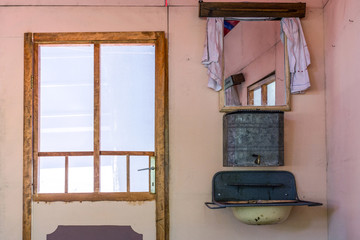 Old retro and vintage house interior with door and very old water tank sink and faucet. Old domestic life concept. Close up