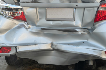 Backside of silver car get damaged by crash accident on the road.