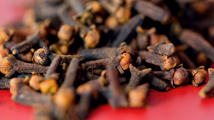 Cloves cooking spices macro closeup. on vintage red wood table, selective focus.