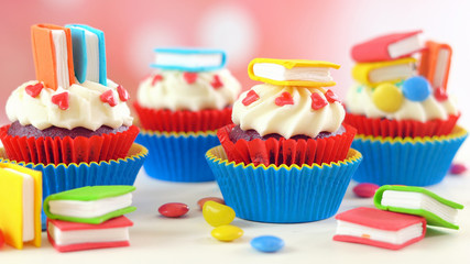 Bright colorful Back to School theme cupcakes with candy sugar art book topper decorations, children's party celebrations.