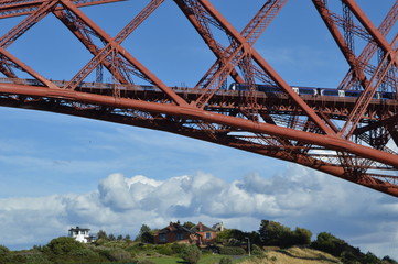 Obraz premium Train passing over the Forth Rail Bridge over the Firth of Forth connecting Edinburgh to Fife, photogrpahed from North Queensferry, Fife
