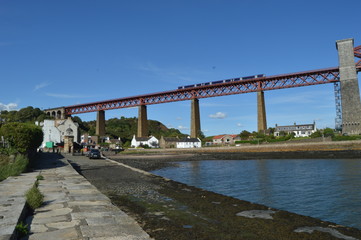 A train crossing the Forth Rail Bridge over the Firth of Forth connecting Edinburgh to Fife, photogrpahed from North Queensferry, Fife