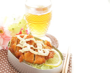 Homemade Japanese bento packed lunch, fried chicken and tartar sauce on rice