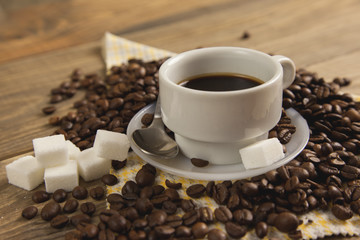 Granos de café y una taza con café caliente