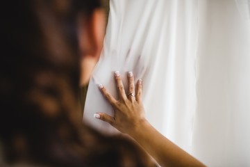 Detail of a white and elegant wedding dress.