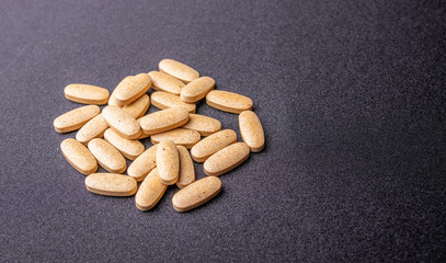 oval brown pills on a dark blue background