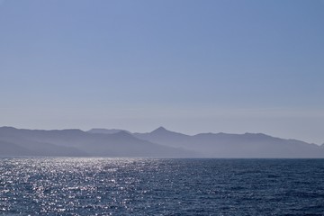 open ocean with island mountains in background 