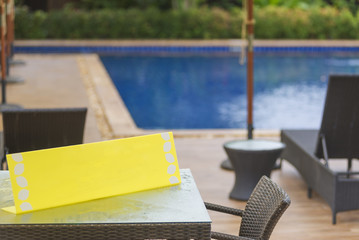 Yellow sign blank copy space for text on a table in pool side